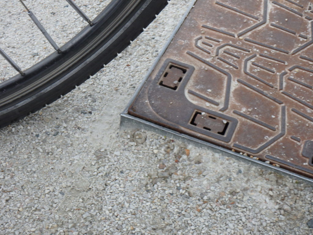 Tours, Deux-Lions : voie verte réalisée en falun. Très rapidement, les plaques d'accès aux réseaux apparaissent... un danger pour les cyclistes @Collectif Cycliste 37